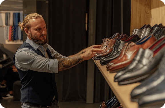 A cobbler reviews financial and business performance analytics in their Silver Spoon dashboard to track growth and expenses in their shoe-making business.