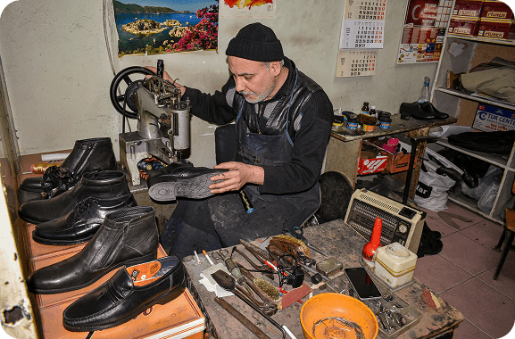 A cobbler is focused on growing their business by promoting their shoe-making services through online platforms and social media.