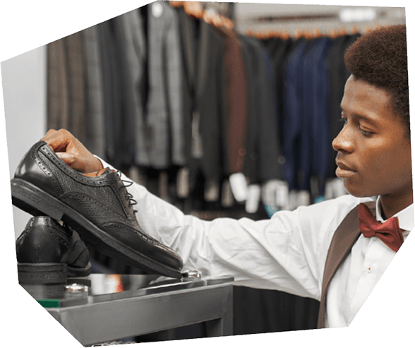 A cobbler carefully inspects a shoe in a retail shop, ensuring quality before selling or repairing it.
